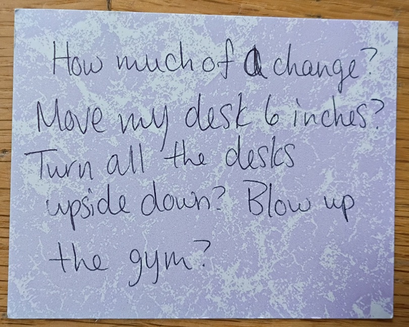 A note reading: How much of a change? Move my desk 6 inches? Turn all the desks upside down? Blow up the gym?