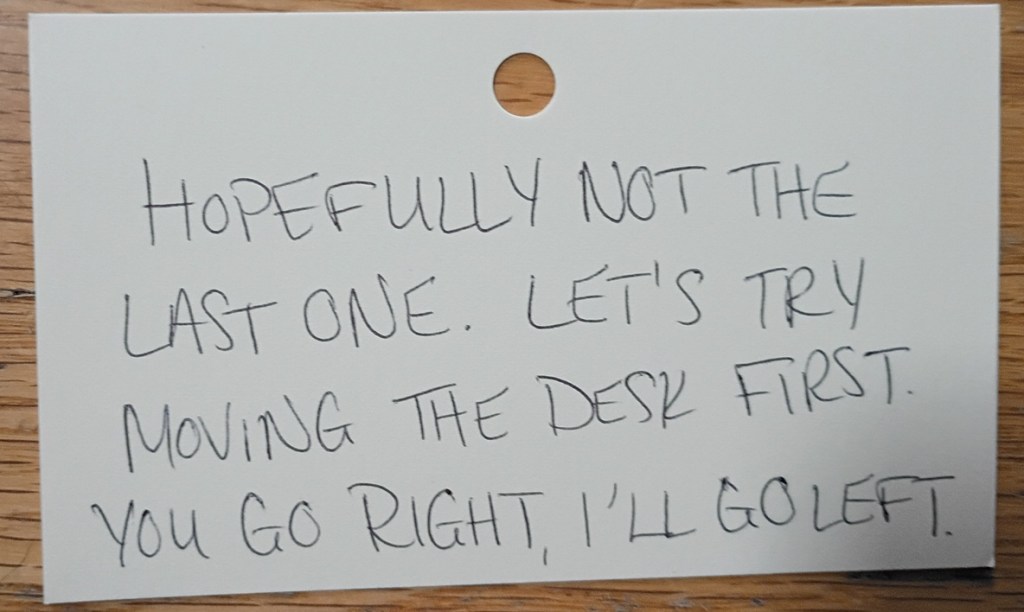 A note reading: Hopefully not the last one. Let's try moving the desk first. You go right, I'll go left.